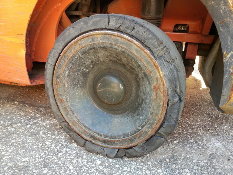 Old, cracked cushion tire on a warehouse forklift